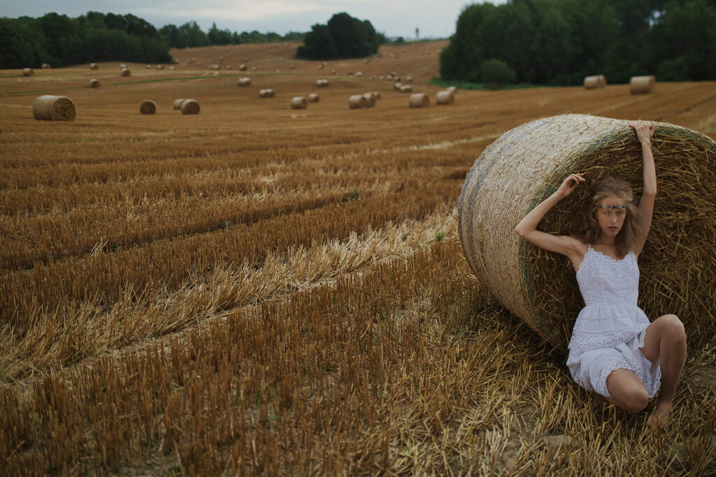 Девушка позирует у стога сена