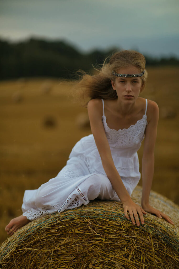 Девушка позирует у стога сена
