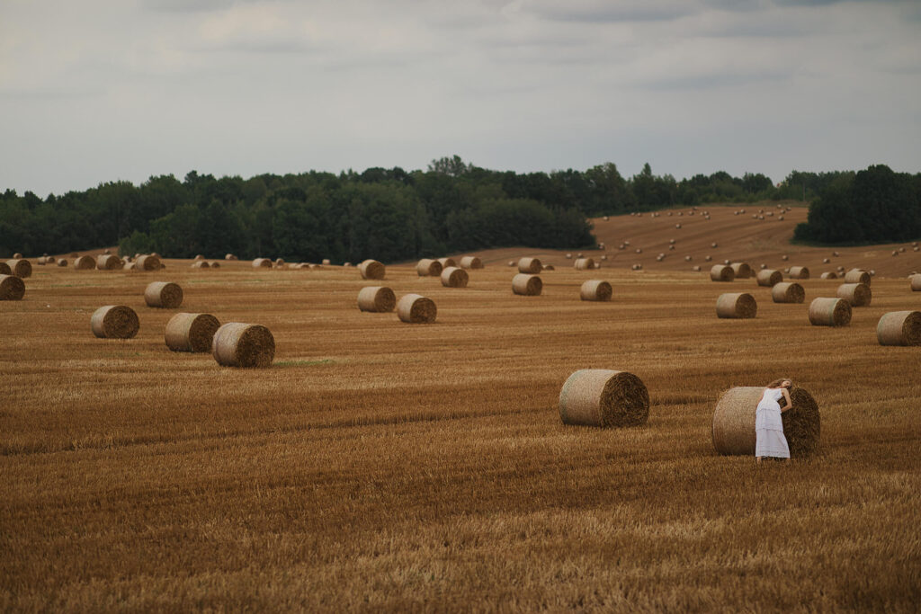 Девушка позирует у стога сена