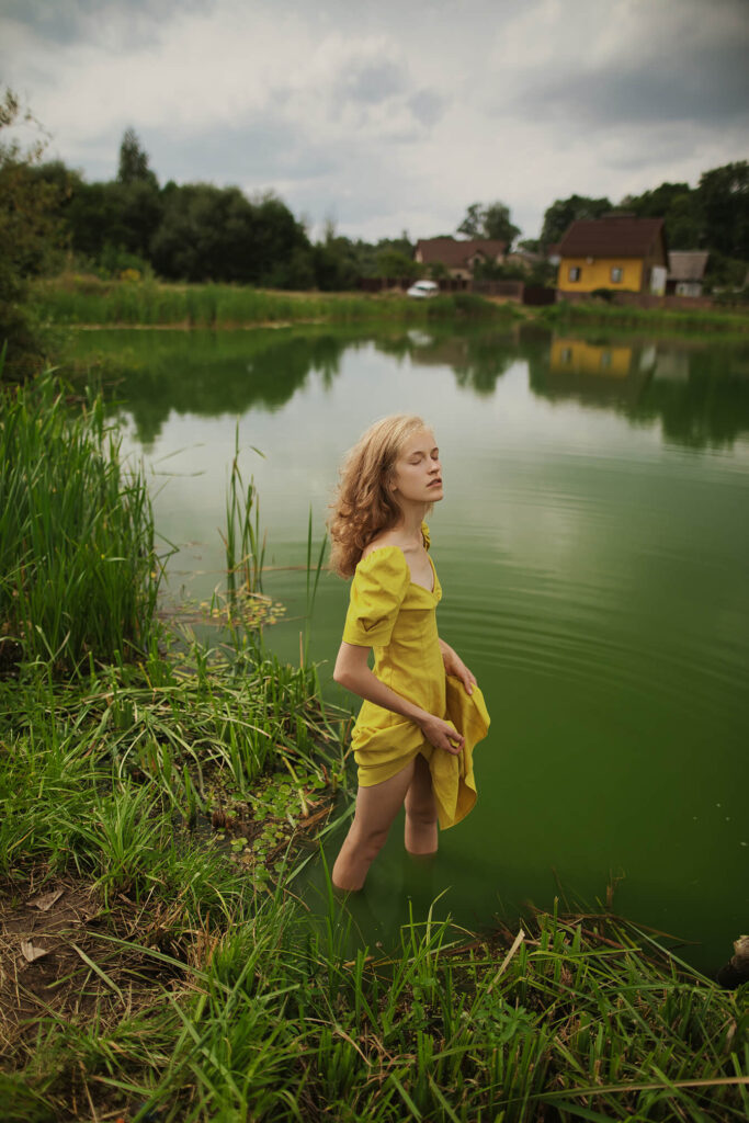 Девушка в желтом платье у берега озера